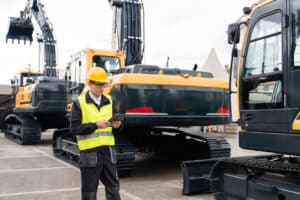 construction worker performing an inspection during excavator maintenance